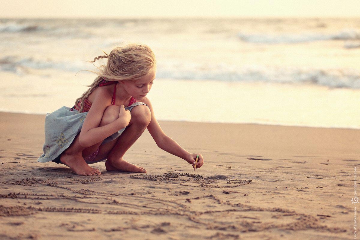 Ласковая милашка любуется горизонтом лежа на песке