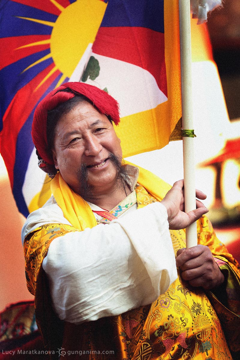 Нарядный тибетец несет флаг Тибета. Фото Люся Маратканова