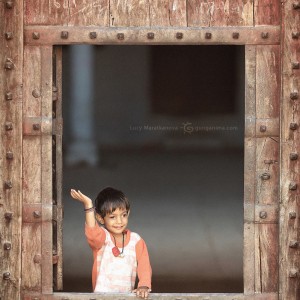 boy is waving from the window in jaipur in india