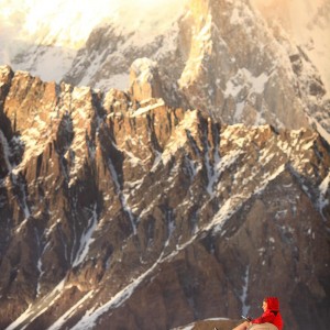 девушка сидит на стуле на фоне огромных гор