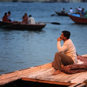 лодочник задумался сидя на корме лодки в варанаси в индии