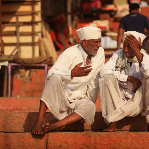 двое мужчин в белом разговаривают на лестнице в варанаси в индии