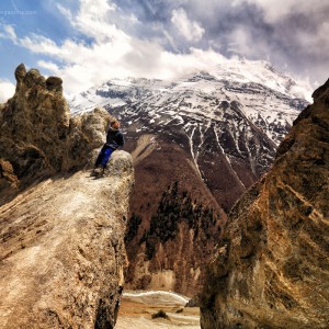 девочка сидит на скале в горах в непале