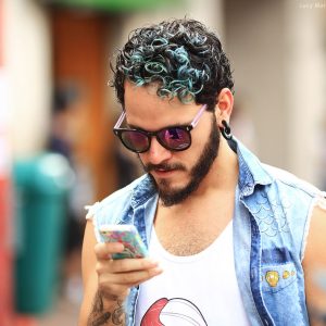 молодой бразилец в очках смотрит в телефон в бразилии