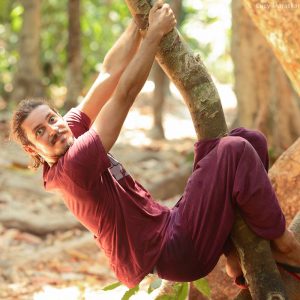 мужчина на дереве дурачится на острове хэвелок в андаманских островах в индии