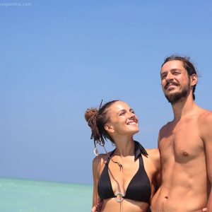 молодая пара улыбается на фоне моря на острове хэвелок в андаманских островах в индии