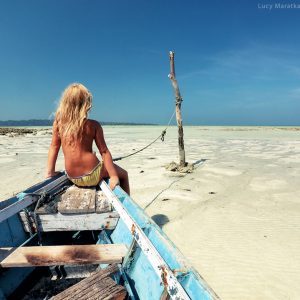 girl is sitting on the boat on the shore of havelock island in andaman in india