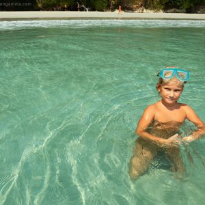 девочка купается в кристально чистой морской воде на берегу острова хэвелок в андаманских островах в индии