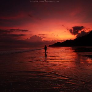 man in the background of the red sunset on havelock island in andaman in india