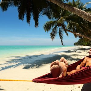 мужчина в гамаке на берегу моря на пляже острова хэвелок в андаманских островах в индии