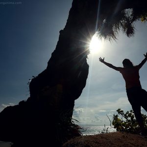 Мужчина с руками воздетыми к солнцу на острове Нил в Андаманских островах в Индии