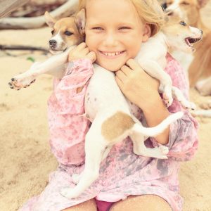 happy girl with puppies in hands in india